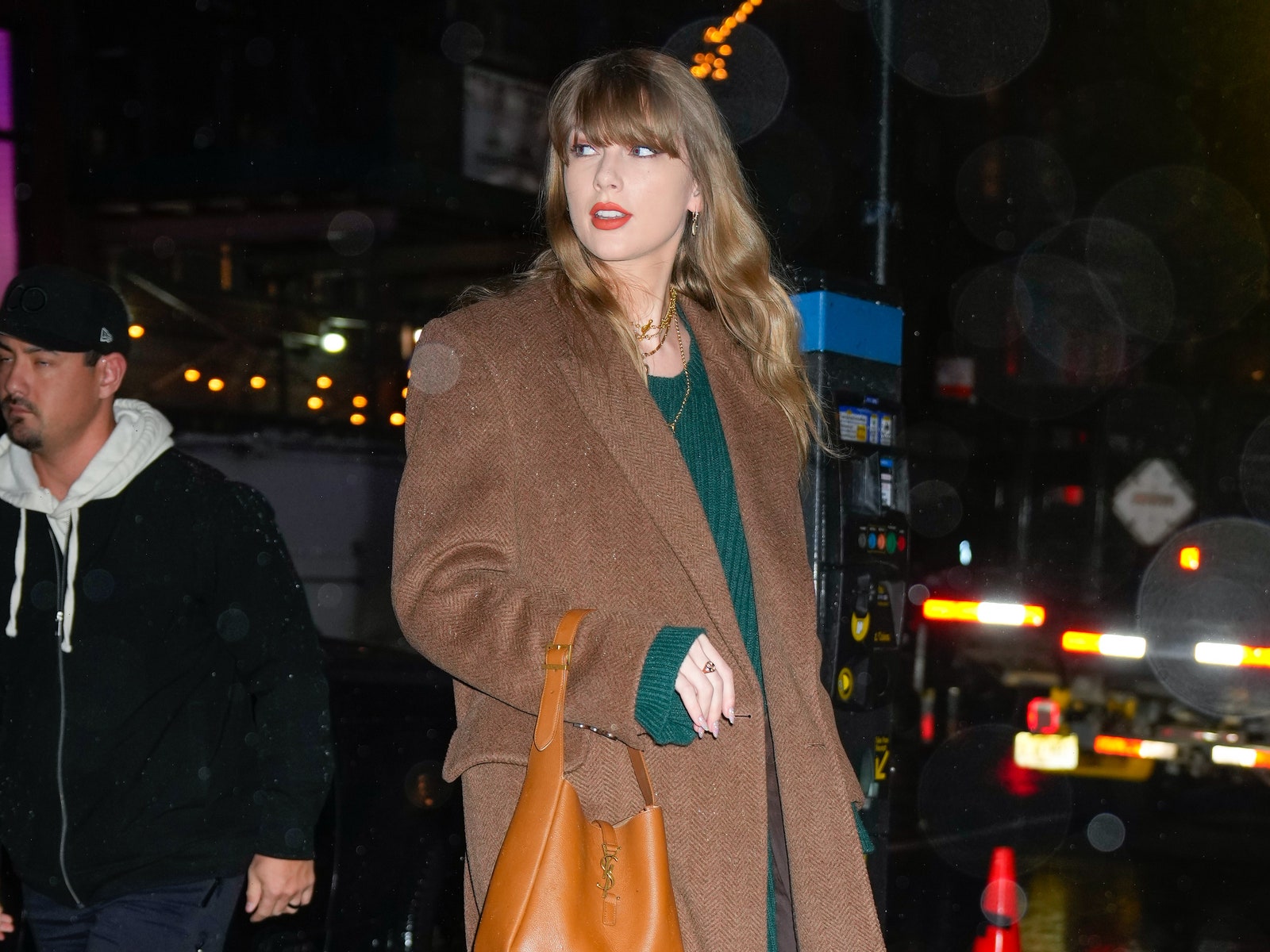 Taylor Swift’s Green Sweaterdress and Brown Coat Combo Screams Evermore to Me